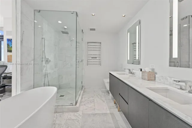 a bathroom with a tub shower vanity and sink