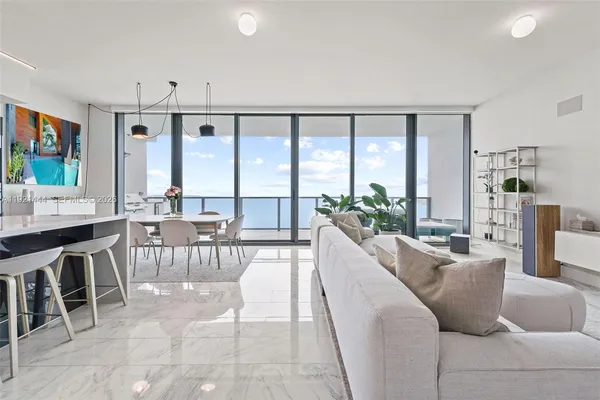 a living room with furniture a large window and a dining table