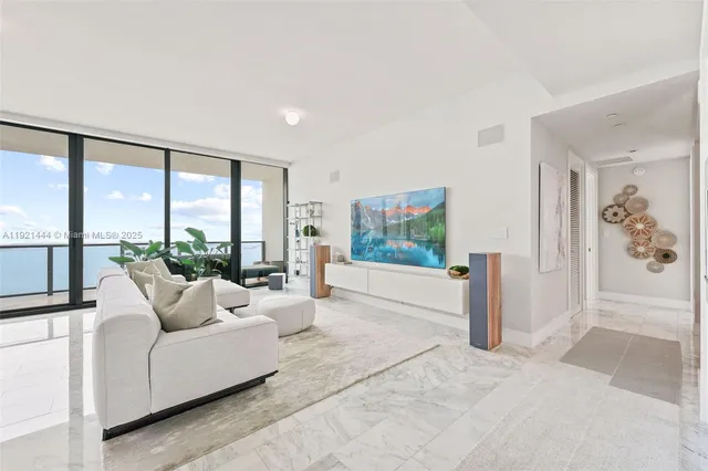 a living room with furniture tv and a floor to ceiling window