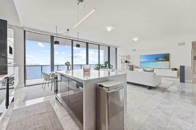 a kitchen with stainless steel appliances kitchen island granite countertop a stove and a dining table with granite countertops