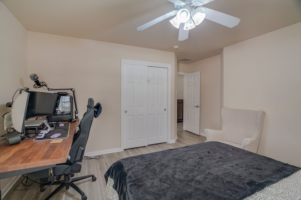 2724 Kickapoo Cavern Drive Pflugerville, TX 78660 - Photo 19 of 24 A well-lit bedroom features durable laminate flooring and a ceiling fan for comfort.
