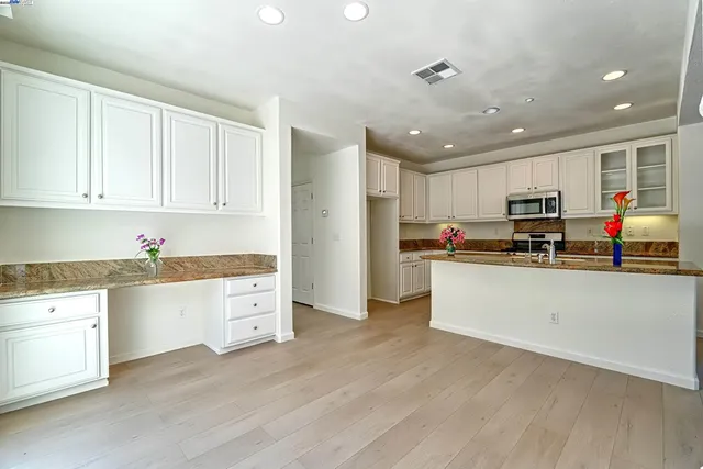 a kitchen with granite countertop white cabinets and white appliances