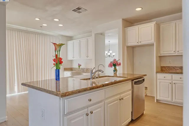 a kitchen with kitchen island granite countertop white cabinets and white appliances