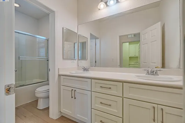 a bathroom with a granite countertop sink mirror and toilet