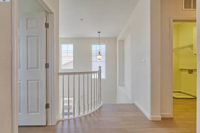 a view of a hallway with windows and wooden floor