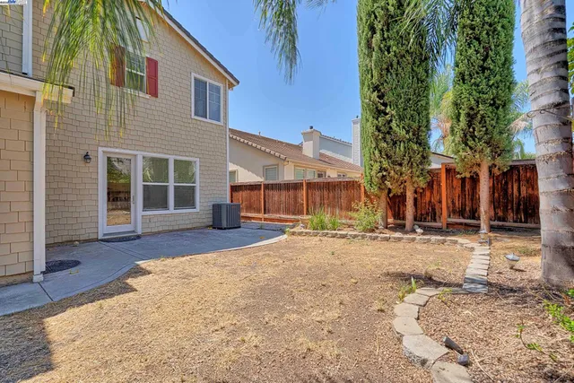 a front view of a house with a dirt yard and a garage