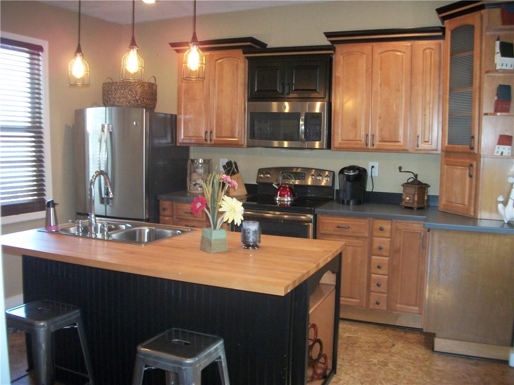 101 Carmichaels Street Rices Landing, PA 15357 - Photo 8 of 28 a kitchen with stainless steel appliances a sink stove and cabinets