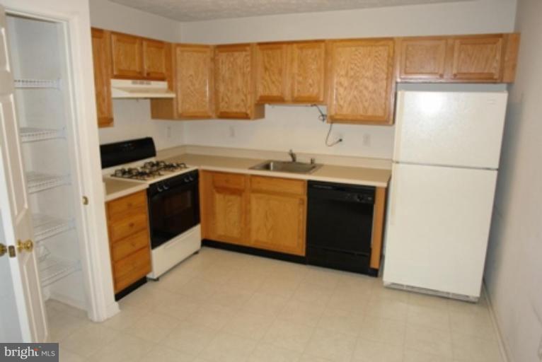 1604 Briarview Court, Unit 64 Severn, MD 21144 - Photo 4 of 10 a kitchen with stainless steel appliances granite countertop a stove a sink and a refrigerator