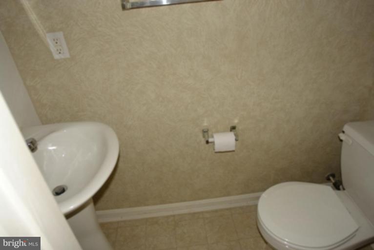 1604 Briarview Court, Unit 64 Severn, MD 21144 - Photo 5 of 10 a white toilet sitting next to a white sink and vanity