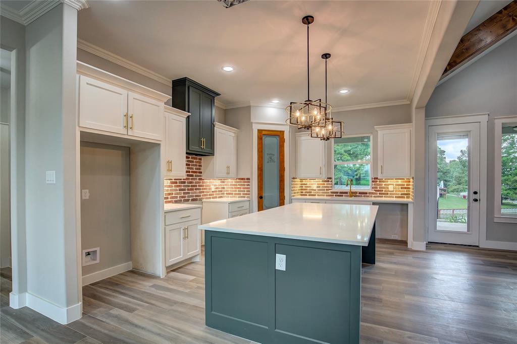 405 Door Key Ranch Road Trinidad, TX 75163 - Photo 10 of 28 Kitchen featuring white cabinets, pendant lighting, light hardwood / wood-style floors, decorative backsplash, and a center island