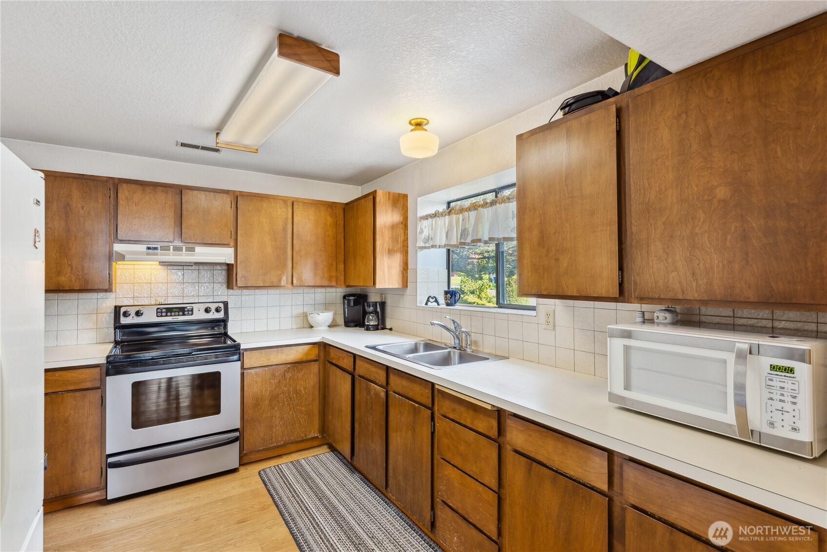 4314 Bryce Drive Anacortes, WA 98221 - Photo 22 of 40 a kitchen with a sink stove and cabinets