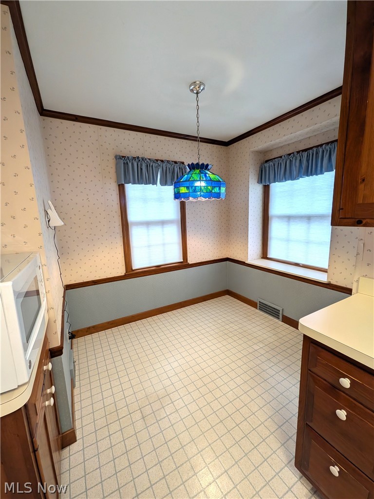 2316 Glendon Road Cleveland, OH 44118 - Photo 8 of 22 Unfurnished dining area with plenty of natural light, wallpapered walls, ornamental molding, and light flooring