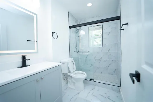 a bathroom with a shower a toilet and sink