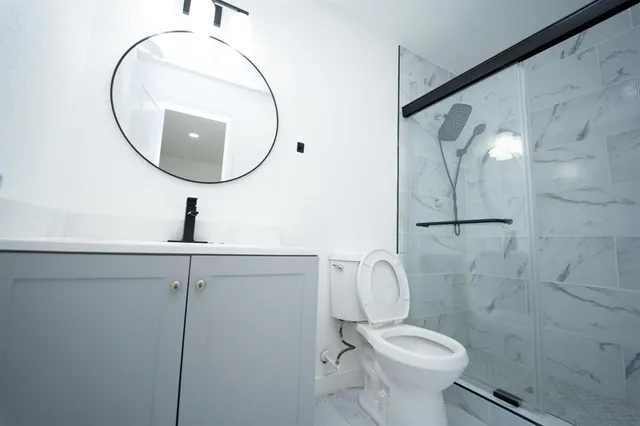 a bathroom with a sink a toilet and shower