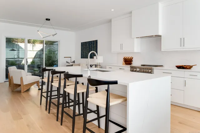 a kitchen with a dining table chairs and white cabinets