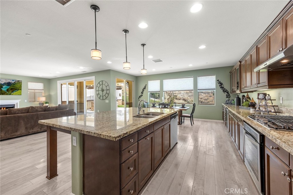 11362 Hutton Road Corona, CA 92883 - Photo 9 of 31 a kitchen with stainless steel appliances granite countertop a sink a stove and a wooden floors