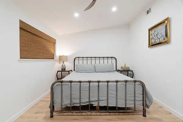 a bedroom with a bed and wooden floor