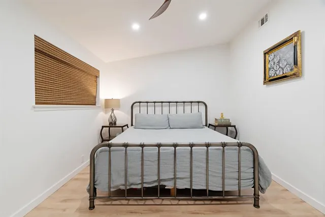 a bedroom with a bed and wooden floor