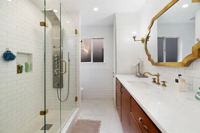 a bathroom with a double vanity sink a mirror and shower