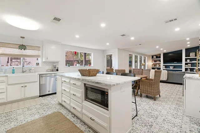 a kitchen with cabinets and chairs