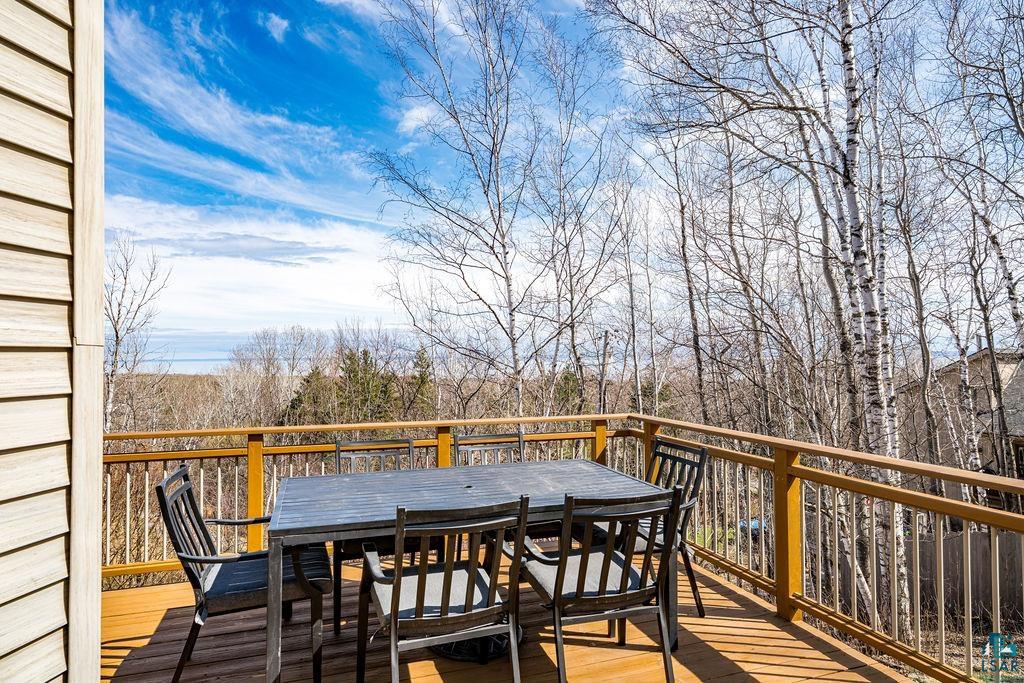 4856 Kingston Street Duluth, MN 55804 - Photo 51 of 88 Spacious wood-finish deck with a wood railing system, offering panoramic tree-lined scenery and a distant body of water