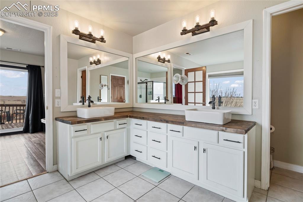20880 Scott Road Calhan, CO 80808 - Photo 32 of 39 a spacious bathroom with a granite countertop double sink and a mirror