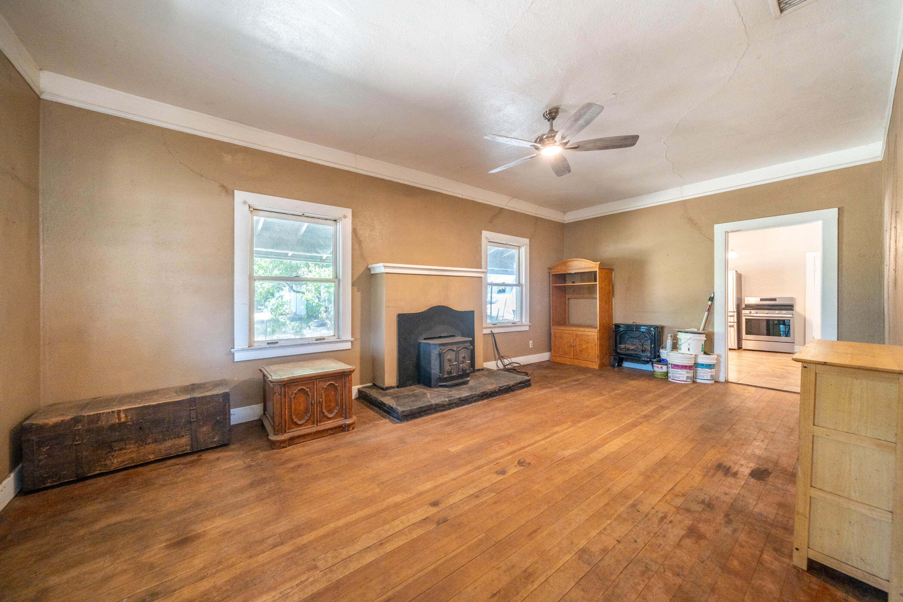 24294 Dersch Road Shingletown, CA 96088 - Photo 15 of 34 a view of a livingroom with a fireplace a ceiling fan and windows