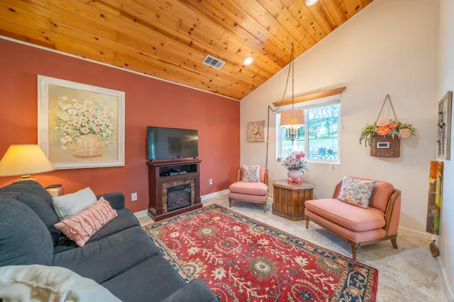 a living room with furniture a rug and a flat screen tv