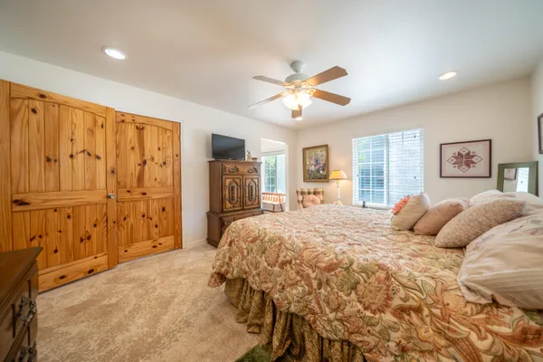a bedroom with a large bed closet and flat tv screen