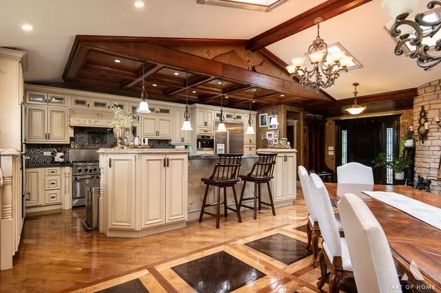 a kitchen with stainless steel appliances kitchen island granite countertop a table chairs and white cabinets