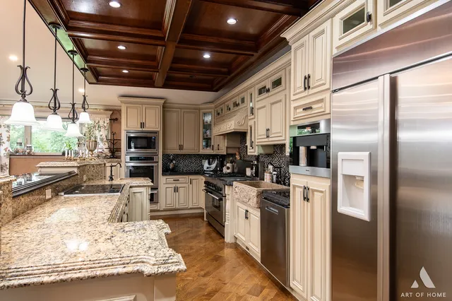 a kitchen with stainless steel appliances kitchen island granite countertop a refrigerator and cabinets