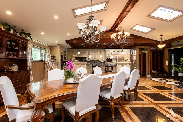 a view of a dining room with furniture a rug and a chandelier
