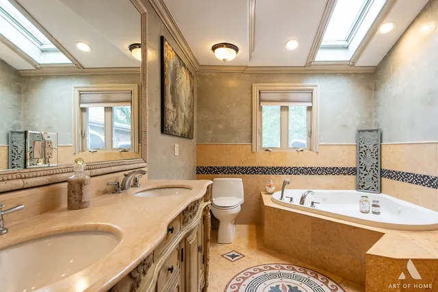 a bathroom with a tub double vanity sink and mirror