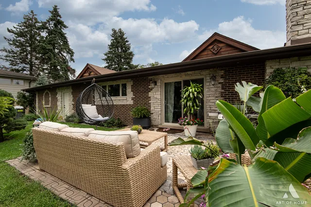 a view of house with backyard and outdoor seating
