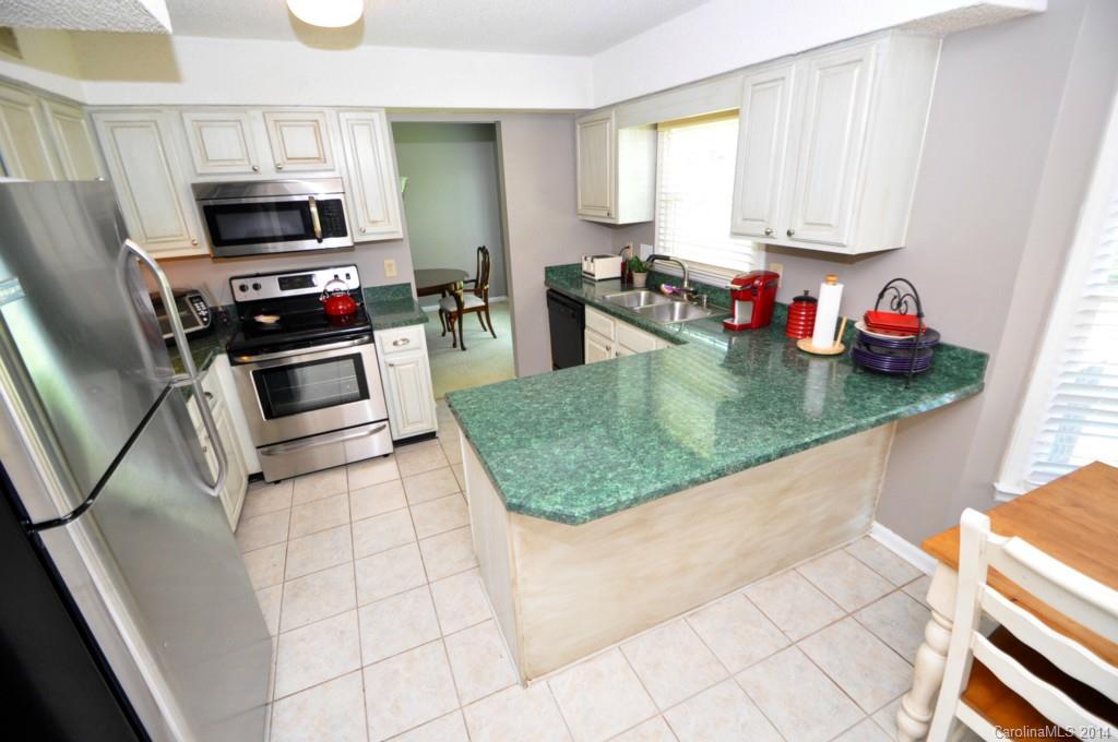 10336 Fairway Ridge Road Charlotte, NC 28277 - Photo 9 of 23 a kitchen with sink a microwave and cabinets