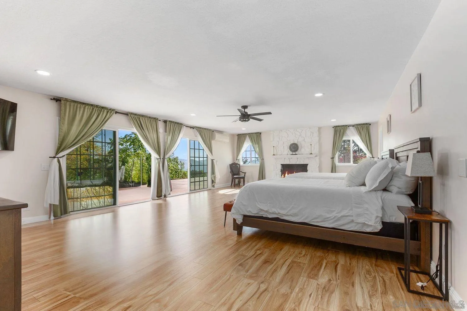 9431 West Lilac Road Escondido, CA 92026 - Photo 21 of 62 a spacious bedroom with a large bed and a wooden floor