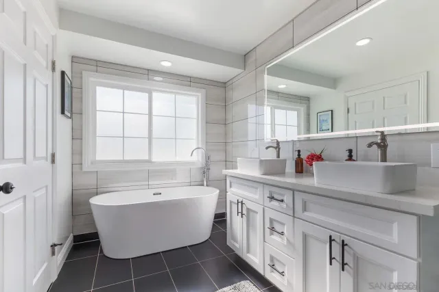 a bed sitting in a spacious bedroom next to a window