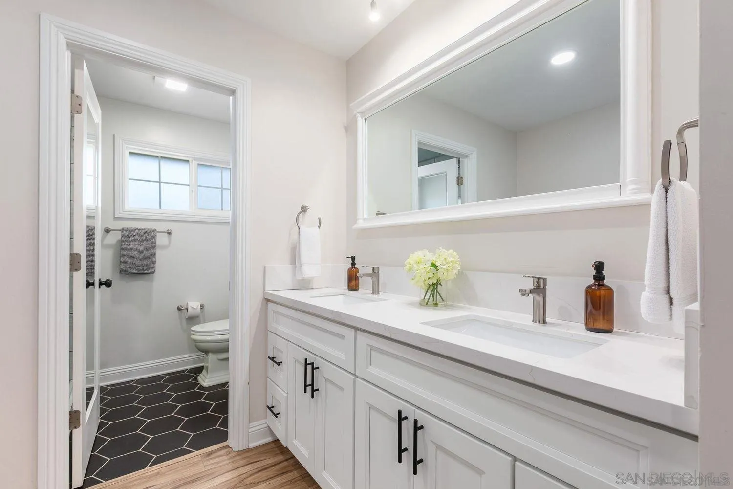 9431 West Lilac Road Escondido, CA 92026 - Photo 28 of 62 a bathroom with a granite countertop sink a toilet and a mirror