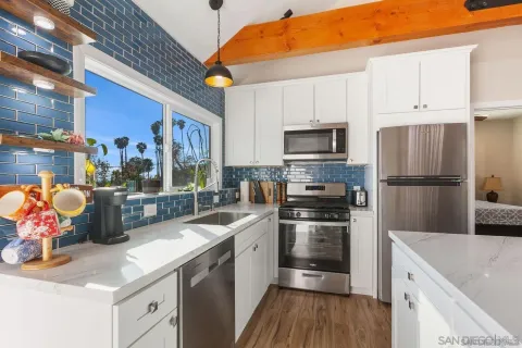 an aerial view of a residential houses with outdoor space and trees