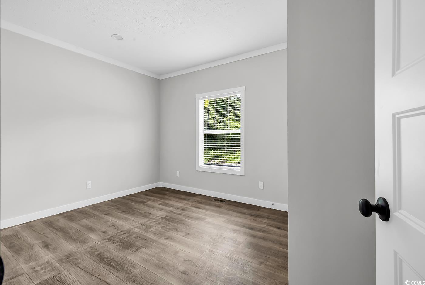 754 Kent Road Andrews, SC 29510 - Photo 16 of 31 Spare room with beam ceiling, a ceiling fan, light wood-type flooring, wooden walls, and a textured ceiling