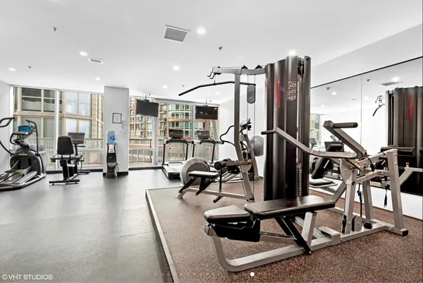 a room with gym equipment and large mirror