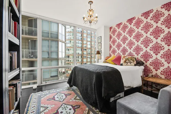 a bedroom with a bed and a book shelf