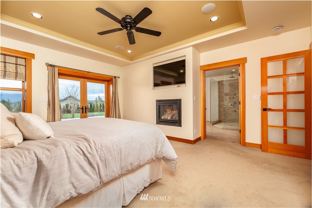 6460 Everson Goshen Road Everson, WA 98247 - Photo 14 of 37 a spacious bedroom with a large bed and a fireplace