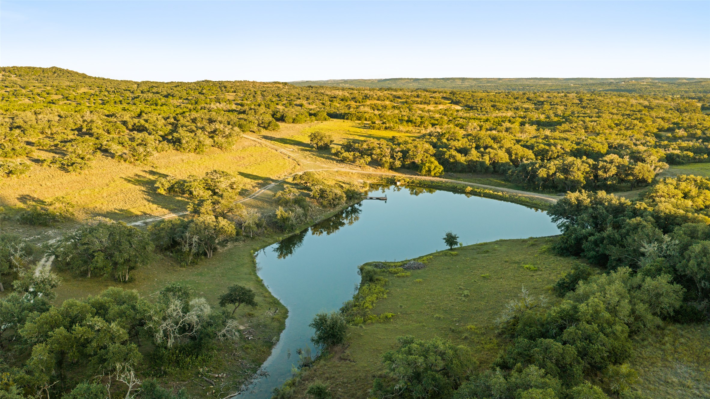 4318 Maenius Road Blanco, TX 78606 - Photo 5 of 11 Rolling green hills surround a tranquil private pond on this vast rural acreage.
