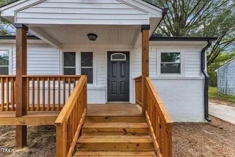 an entrance view of a house with wooden stairs