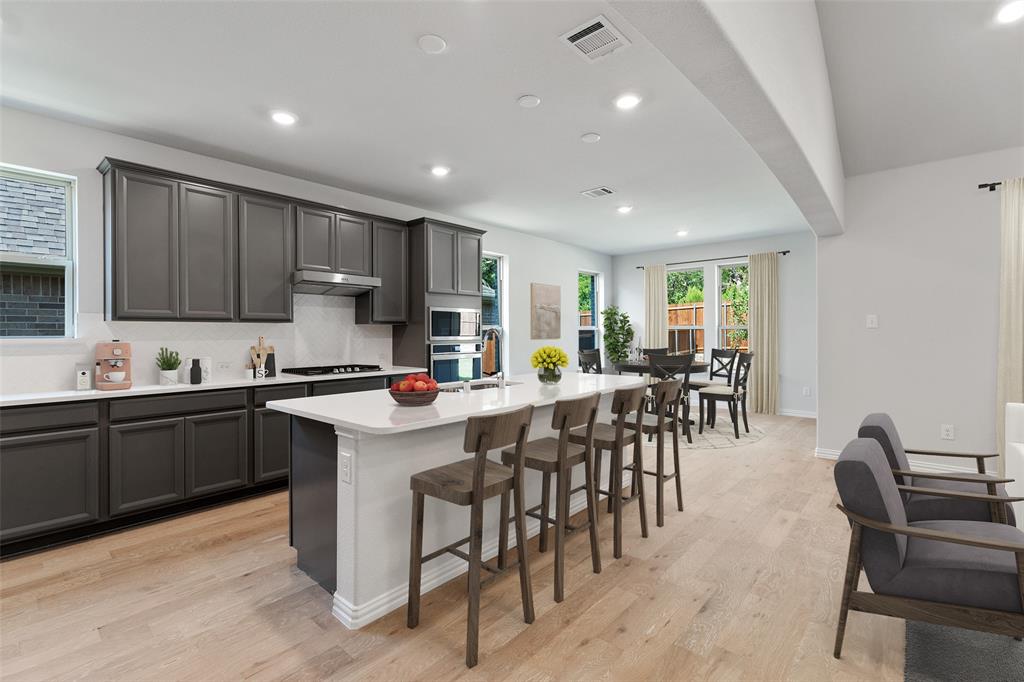 715 Soprano Drive Forney, TX 75126 - Photo 5 of 16 a kitchen with appliances a table and chairs in it