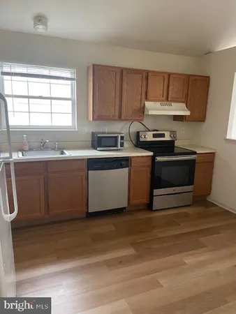 a kitchen with stainless steel appliances granite countertop a sink a stove a microwave a counter top and cabinets