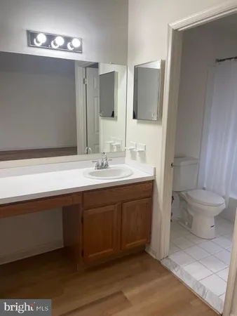 a spacious bathroom with a toilet sink and mirror