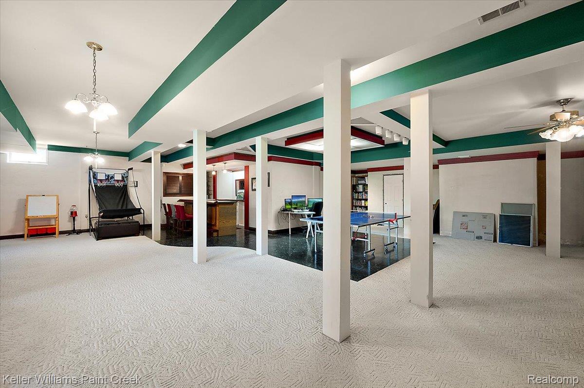 69069 Campground Road Romeo, MI 48065 - Photo 67 of 78 Expansive finished basement featuring recessed lighting, a built-in bar, white wall paneling, and a combination of patterned carpet and dark tile flooring