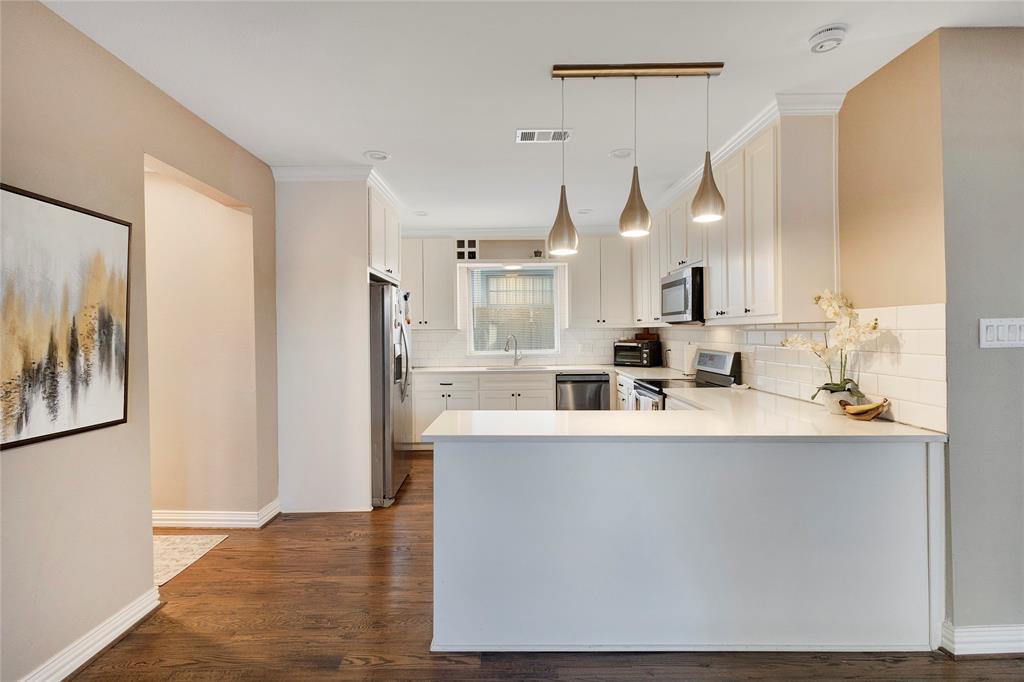 828 Elsbeth Street Dallas, TX 75208 - Photo 11 of 35 a kitchen with kitchen island a sink a stove a refrigerator and a window